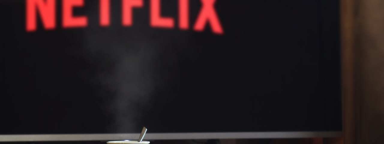 Komoda na kojoj se nalazi tv na kojem je uključen Netfliks